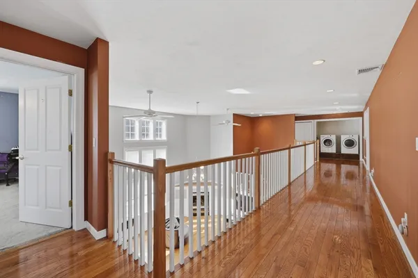 a view of a hallway with wooden floor and stairs