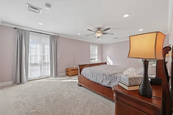 a spacious bedroom with a bed and dresser