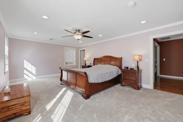 a bedroom with a bed chandelier and a window