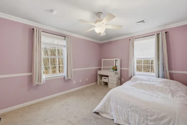 a spacious bedroom with a bed next to a window with a chandelier