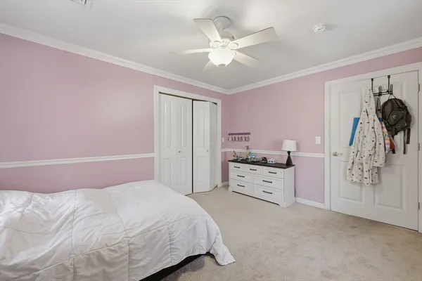 a spacious bedroom with a bed and a ceiling fan