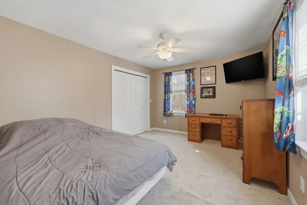 a bedroom with a bed flat screen tv and a couch