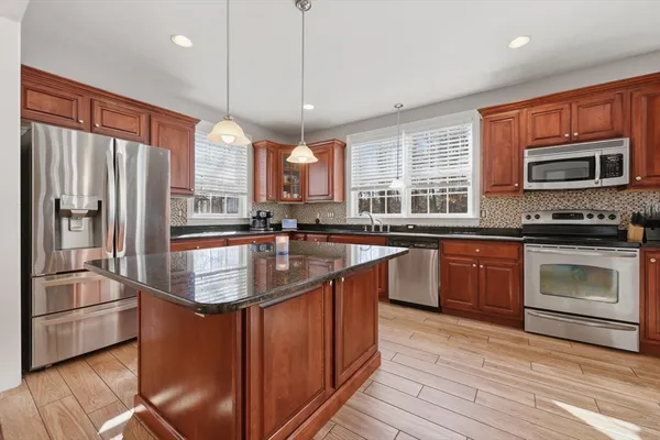 a kitchen with stainless steel appliances granite countertop a sink stove and refrigerator