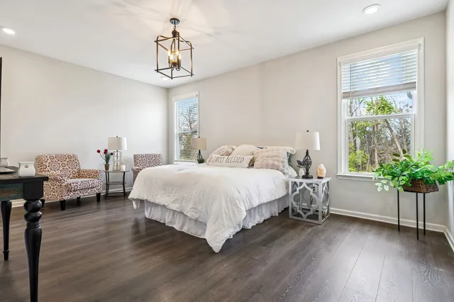 a bedroom with bed and a chandelier