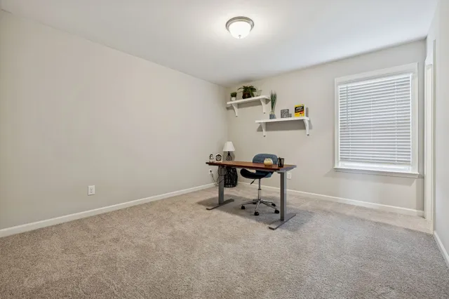 a view of a workspace with furniture and a window