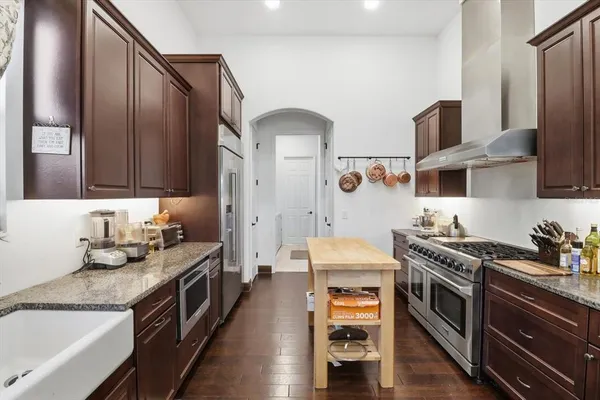 a kitchen with stainless steel appliances granite countertop a stove a sink and a refrigerator