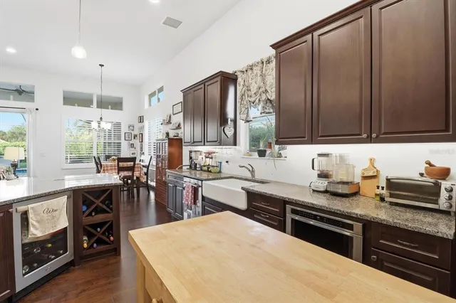 a kitchen with stainless steel appliances granite countertop a stove a sink and a dining table with wooden floor