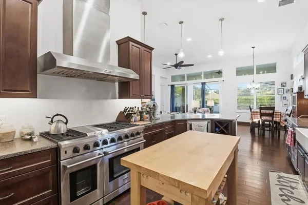a kitchen with stainless steel appliances granite countertop a stove refrigerator and sink