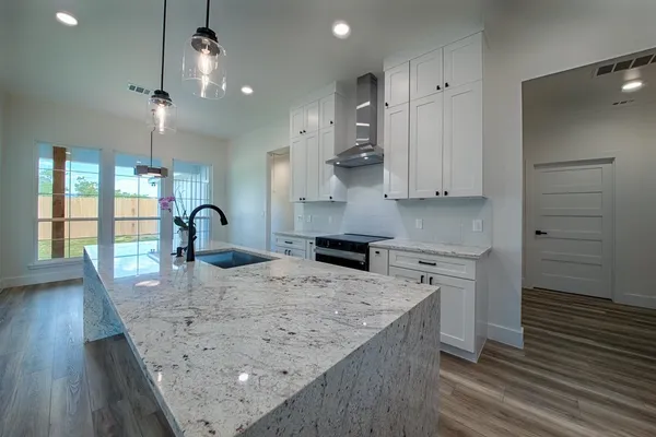 a kitchen with kitchen island a counter top space a sink stainless steel appliances and cabinets