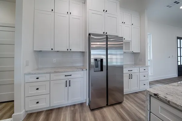 a kitchen with stainless steel appliances white cabinets and a refrigerator
