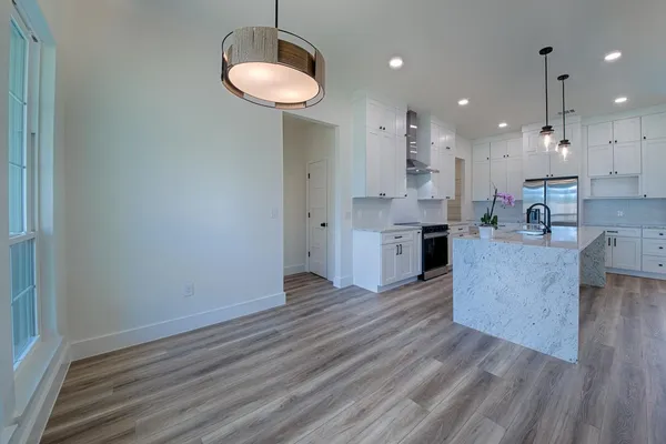 a kitchen with stainless steel appliances granite countertop a stove a sink and a refrigerator