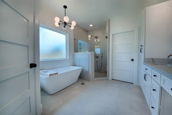 a spacious bathroom with a granite countertop sink a large mirror and a bathtub