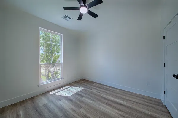a view of a room with wooden floor closet and windows
