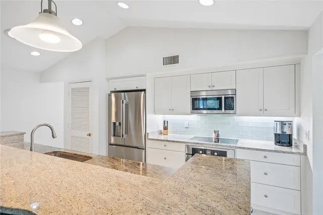 a kitchen with stainless steel appliances granite countertop a sink and cabinets
