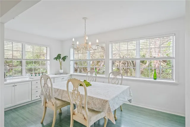 a view of a dining room with furniture large windows and wooden floor