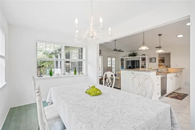a bedroom with a bed a chandelier and flat screen tv