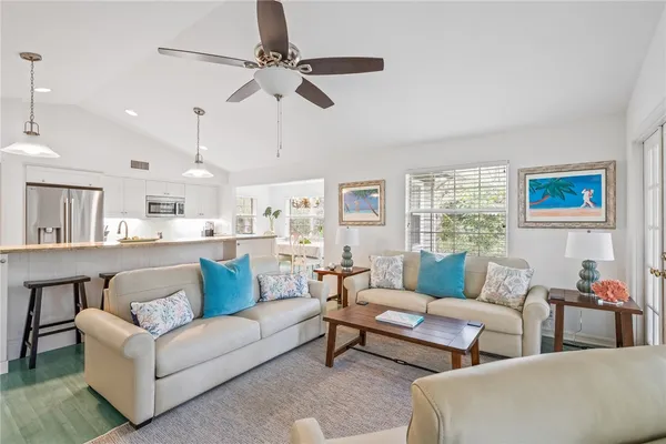 a living room with furniture kitchen area and a window