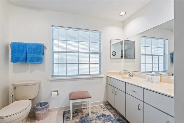 a spacious bathroom with a toilet sink and mirror