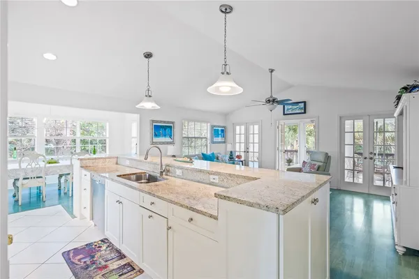 a kitchen with granite countertop kitchen island stainless steel appliances a sink and a wooden floor