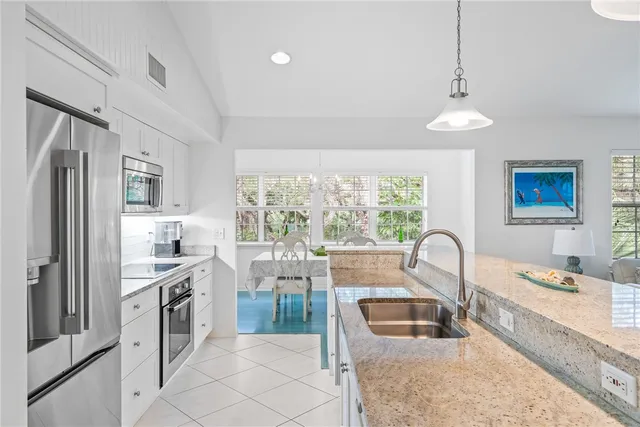a kitchen with granite countertop a refrigerator stove top oven and sink