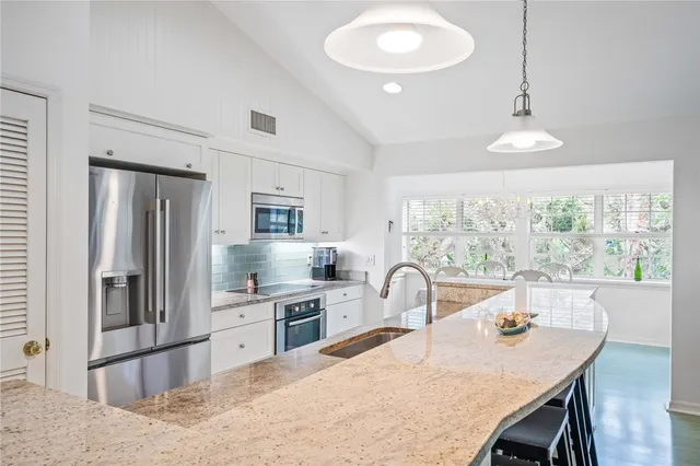a kitchen with a table chairs refrigerator and stove