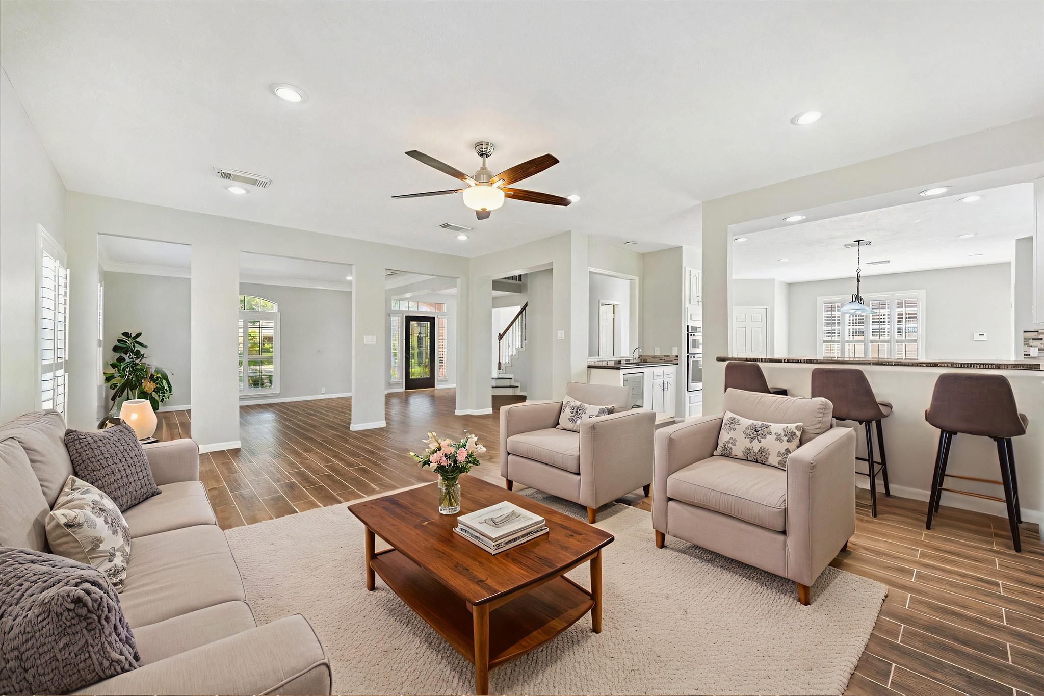 2006 Raven's Crest Drive Sugar Land, TX 77478 - Photo 7 of 29 a living room with furniture a wooden floor and a chandelier