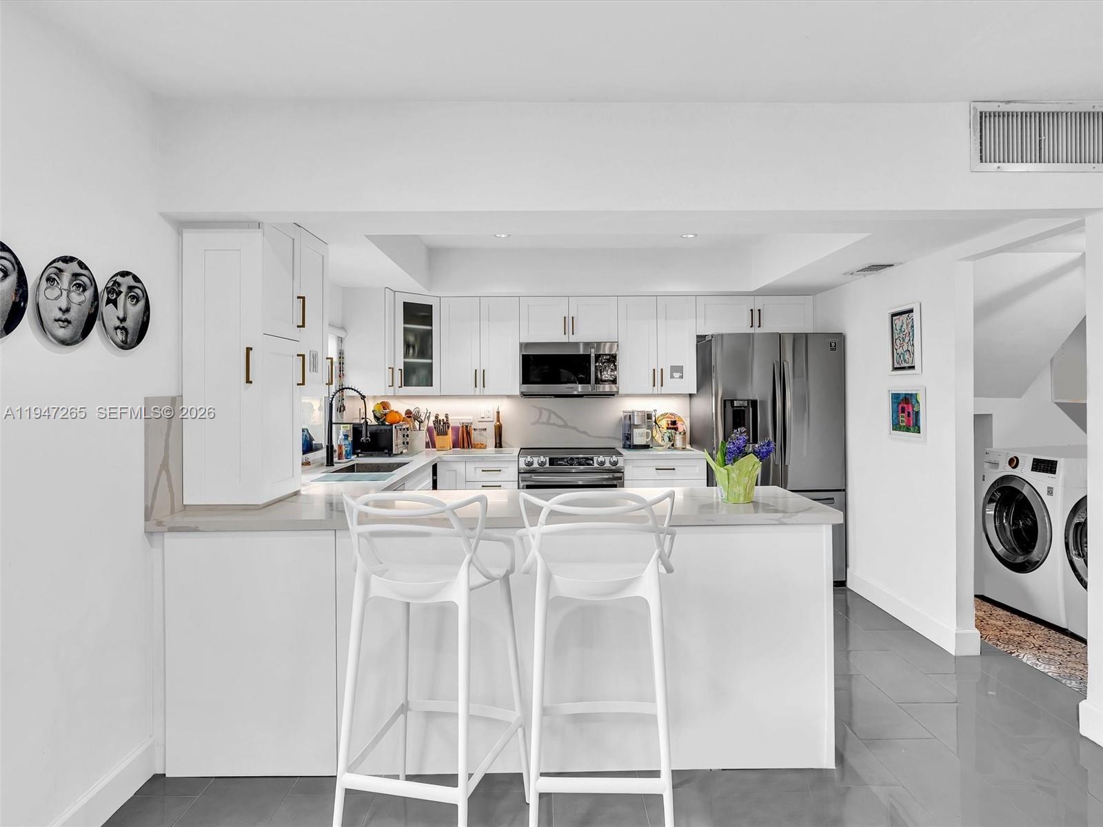 7661 Southwest 102nd Place Miami, FL 33173 - Photo 11 of 51 a kitchen with stainless steel appliances granite countertop a refrigerator and a stove top oven
