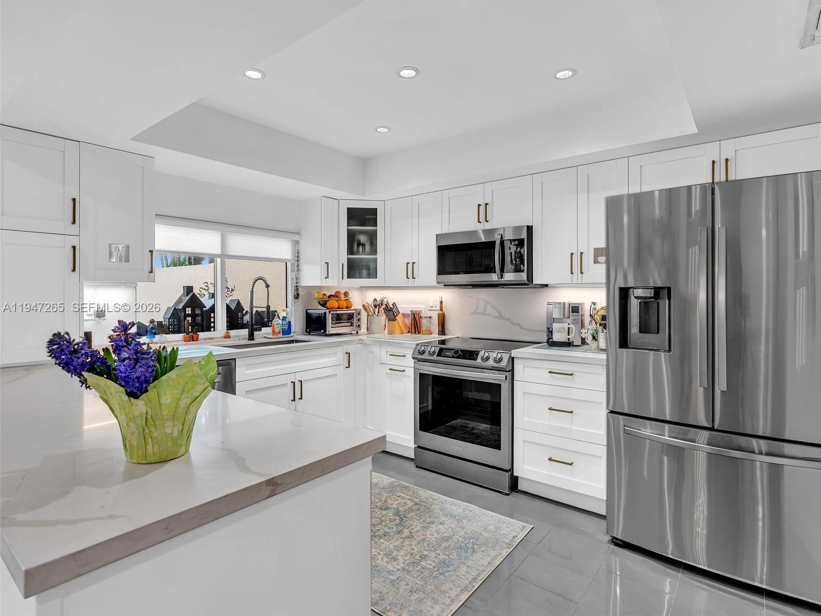 7661 Southwest 102nd Place Miami, FL 33173 - Photo 12 of 51 a kitchen with granite countertop stainless steel appliances and refrigerator