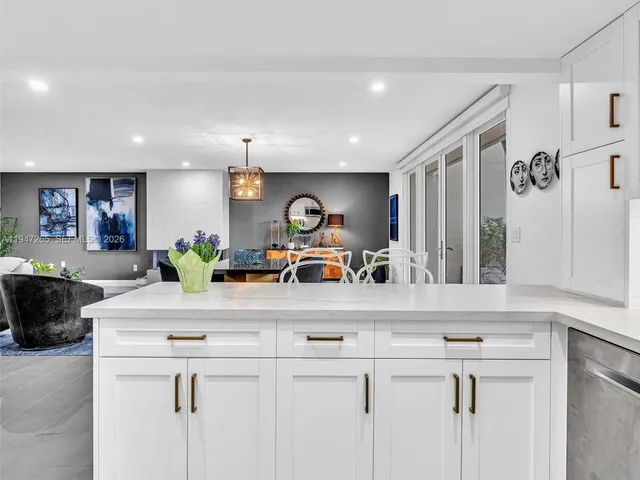 a bedroom with a large bed a chandelier and windows
