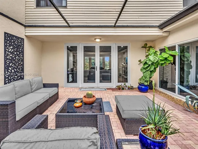 a spacious bedroom with a bed chandelier and a flat screen tv