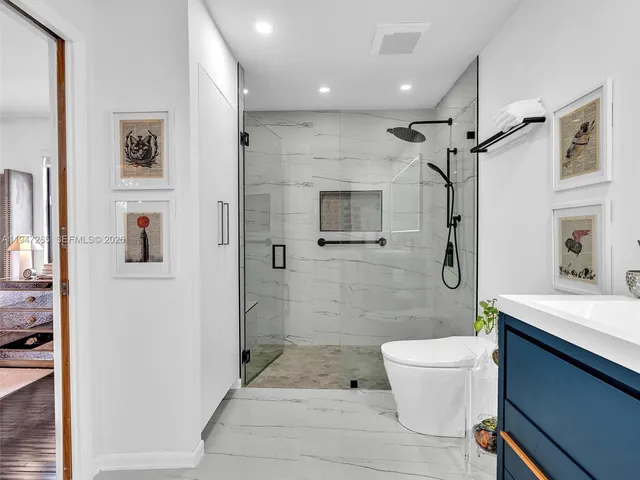 a bathroom with a granite countertop sink toilet and shower