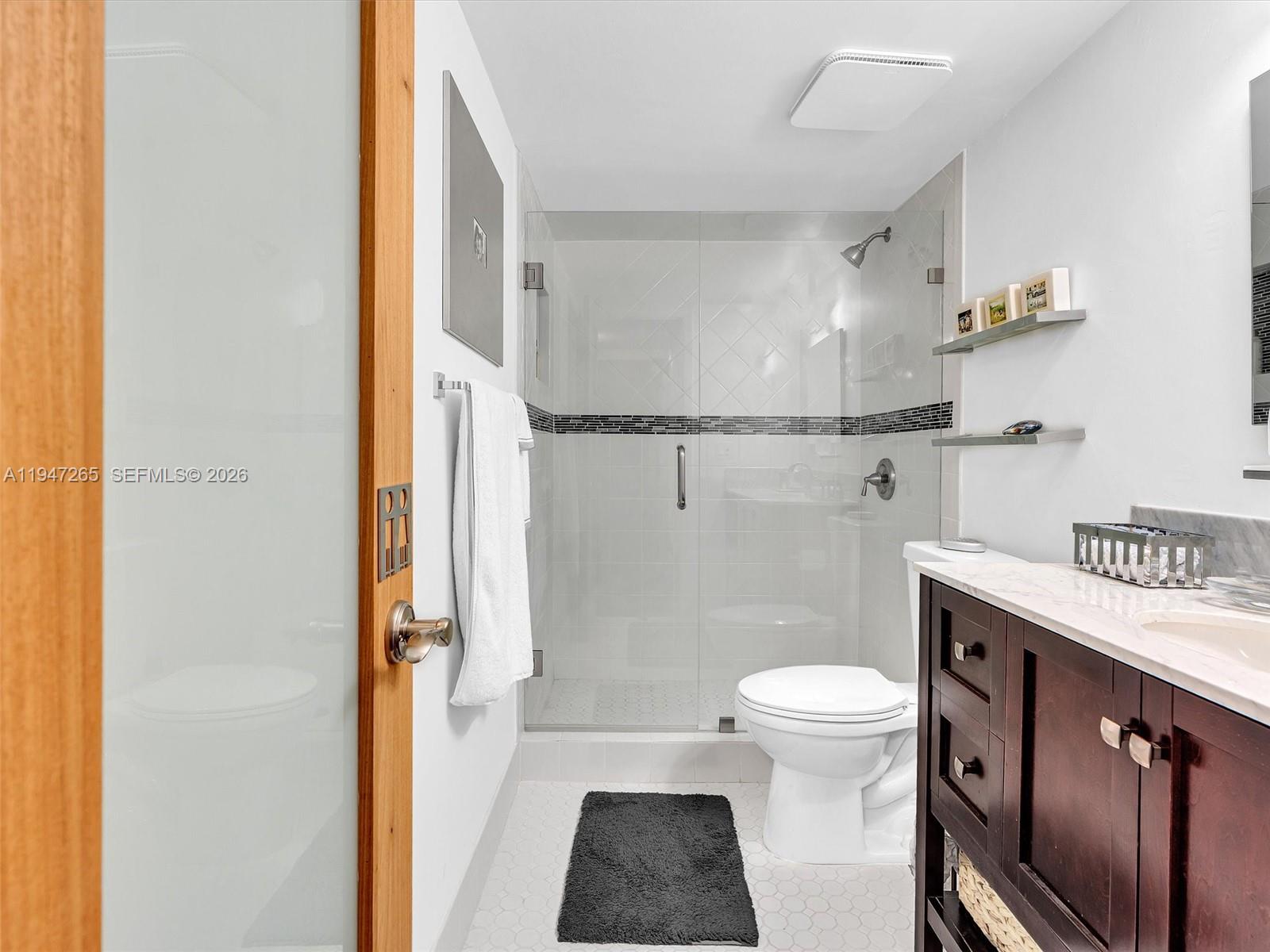 7661 Southwest 102nd Place Miami, FL 33173 - Photo 23 of 51 a bathroom with a granite countertop sink toilet and shower