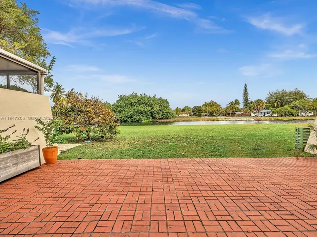 a front view of a house with garden and trees