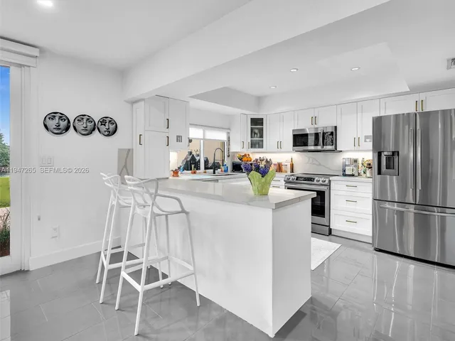 a kitchen with stainless steel appliances granite countertop a refrigerator and a stove top oven