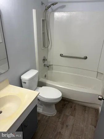 a white toilet sitting next to a bath tub and a shower