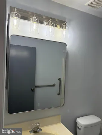 a bathroom with a granite countertop sink and a toilet