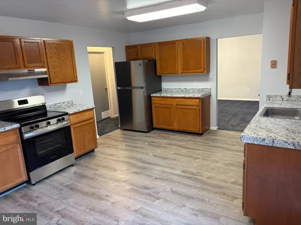 a kitchen with granite countertop wooden floors and stainless steel appliances