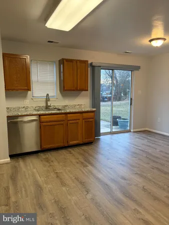 a view of a kitchen with wooden floor and stainless steel appliances