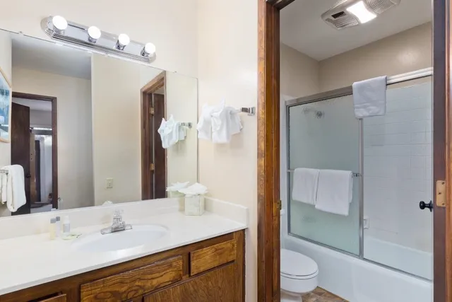 a bathroom with a sink a toilet and shower