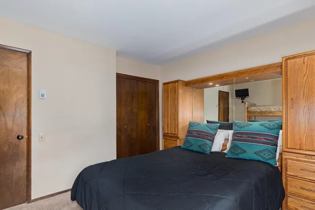 a bedroom with a large bed and a dresser