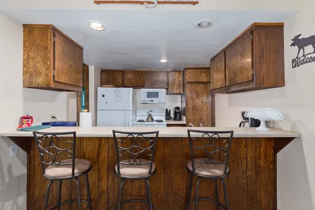 a kitchen with a sink a stove and chairs