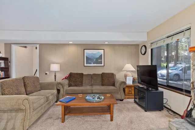 a living room with furniture a flat screen tv and a window