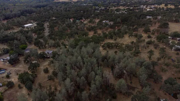 an aerial view of house with yard and mountain view in back