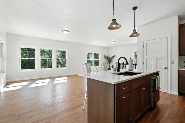 a kitchen with a sink a window and wooden floor
