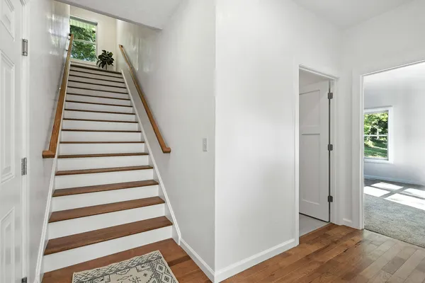 a view of a hallway with wooden floor and entryway