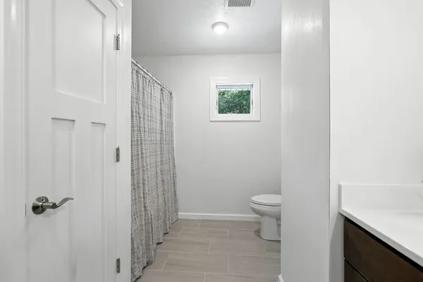 a bathroom with a toilet a sink and shower