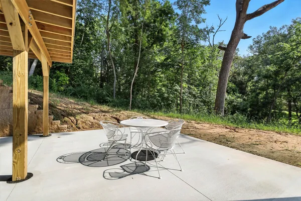 a view of a patio with table and chairs and potted plants with wooden fence