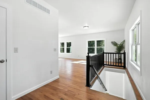 a view of a livingroom with furniture wooden floor and windows