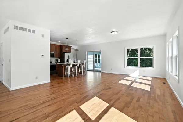 a view of dining room with kitchen island and wooden floor