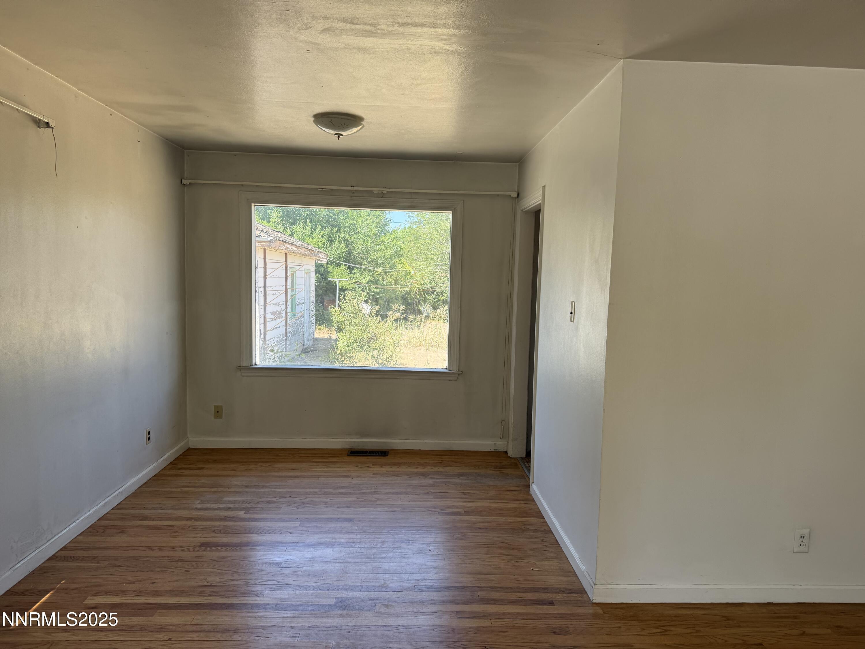 1075 Memory Lane Reno, NV 89509 - Photo 3 of 11 an empty room with wooden floor and windows